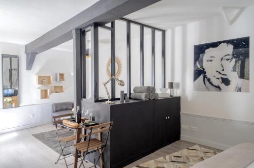 d'un salon avec une table et une peinture murale. dans l'établissement Keyz - Elegant Studio with Terrace near the Louvre & Le Marais, à Paris