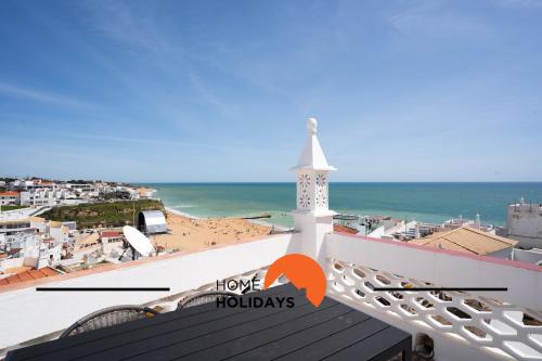 une vue de la plage depuis un bâtiment avec une tour d'horloge dans l'établissement #306 Rua do Saco 11 by Home Holidays, à Albufeira