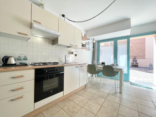 a kitchen with a stove and a table with chairs at Nel Cuore di Santarcangelo – Casa Bellaere in Santarcangelo di Romagna