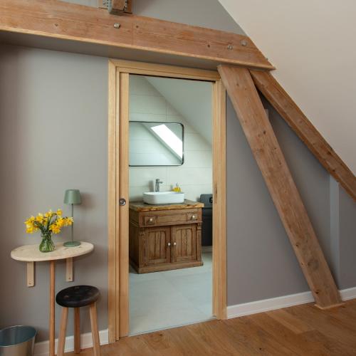 La salle de bains est pourvue d'une porte menant à un lavabo. dans l'établissement La Porte d'Arcy - grand jardin et piscine privée, à Fère-en-Tardenois