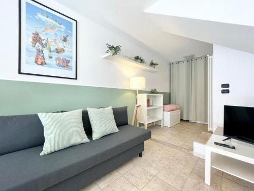 a living room with a couch and a television at Nel Cuore di Santarcangelo – Casa Bellaere in Santarcangelo di Romagna