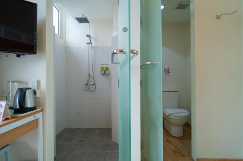 bagno con servizi igienici e TV. di MySpace Hotel Comembo Taguig a Manila