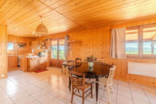- une cuisine avec un plafond en bois, une table et des chaises dans l'établissement Le Chalet Brionnais - Grand Jardin, à Saint-Didier-en-Brionnais