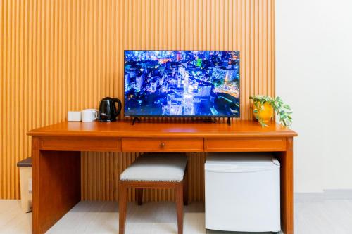 a wooden desk with a television on top of it at Corvel by Behomy in Jakarta