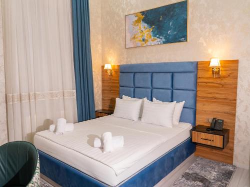 - une chambre avec un lit bleu et des oreillers blancs dans l'établissement Avant Wellness Hotel Pool&Spa, Free airport shuttle service, à Tachkent