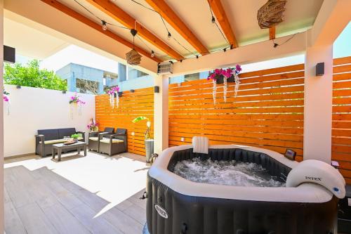 a hot tub in the middle of a patio at Harmony Studio Apartment in Ialyssos
