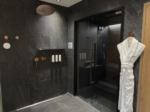 a black bathroom with a shower with a glass door at Swissôtel Damian Jasna in Demanovska Dolina