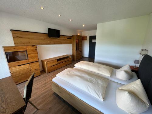 a bedroom with a large white bed and a desk at Landhotel Löwen in Blumberg