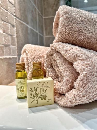 une bouteille d'huiles essentielles à côté d'une pile de serviettes dans l'établissement Magnifique villa au calme, Vue mer, piscine, à Ollioules