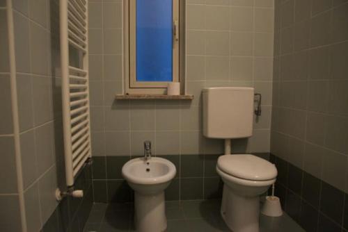 a bathroom with a toilet and a sink and a window at Alessandro in Trieste