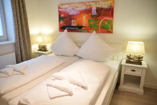 ein Schlafzimmer mit zwei Betten mit weißen Laken und Kissen in der Unterkunft Viktoria 4 you - Whg. 04 in Westerland