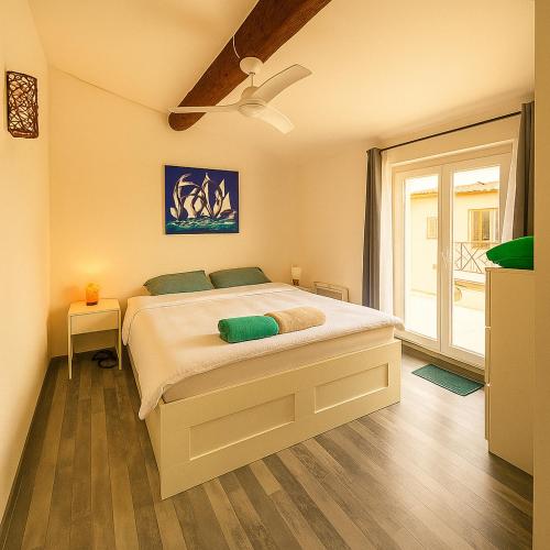 une chambre avec un grand lit blanc avec une fenêtre dans l'établissement Maison au cœur de La Couronne Mer et commerces à pied, à Martigues