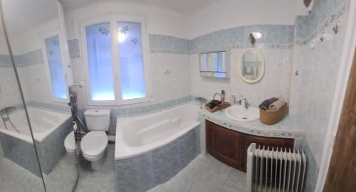 a bathroom with a tub and a toilet and a sink at Chedia lazidi in La Celle-sous-Gouzon