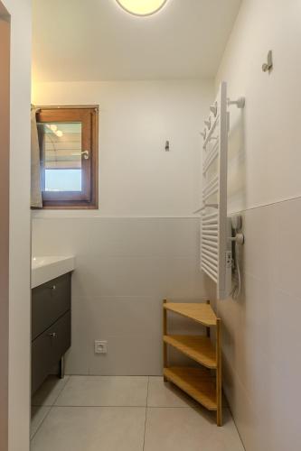 La salle de bains est pourvue d'un lavabo, d'une étagère et d'un miroir. dans l'établissement Appartement avec superbe vue montagne, à Arâches-la-Frasse