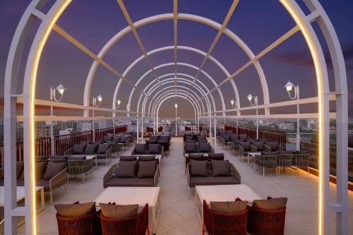 a room with tables and chairs on a roof at Keys Prima by Lemon Tree Hotels, Kota, Rajasthan in Kota