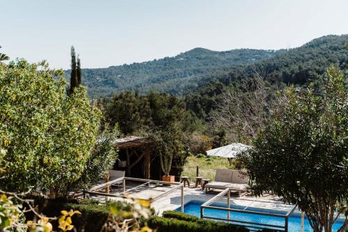 a villa with a pool and mountains in the background at Valley Club - Agroturismo Ibiza in Sant Joan de Labritja