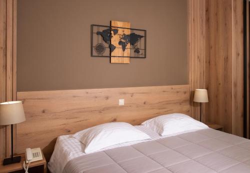 a bedroom with a white bed with a wooden headboard at Marina Alimos Hotel Apartments in Athens