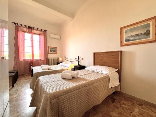 een slaapkamer met twee bedden met handdoeken erop bij Abbadia Panoramic Terrace in Siena