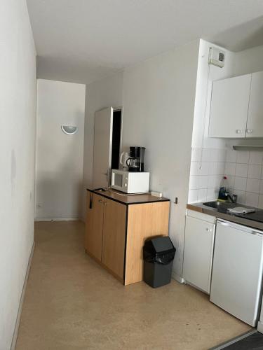 a small kitchen with a microwave on top of a counter at KOSY Appart'Hôtels - La Maison Des Chercheurs in Vandoeuvre-lès-Nancy