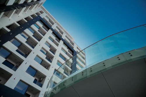 a tall apartment building with a glass facade at NOYA - Hotel Building Stefan Resort II in Mamaia Sat/Năvodari