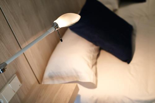 a lamp on a wall with a pillow and an umbrella at Hotel Colonial in Colonia Sant Jordi