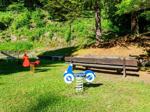 a park with a bench and toys in the grass at Campeggio Internazionale Madonna del Ghisallo in Magreglio