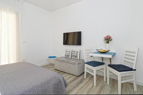 a bedroom with a bed and a table and chairs at Studio Apartments Nada in Umag