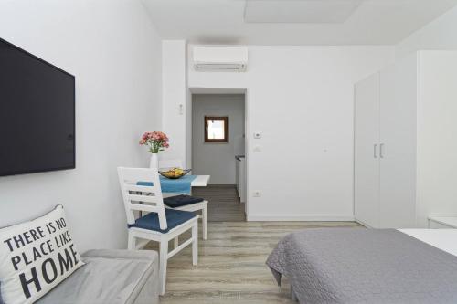 a bedroom with a bed and a tv and a chair at Studio Apartments Nada in Umag