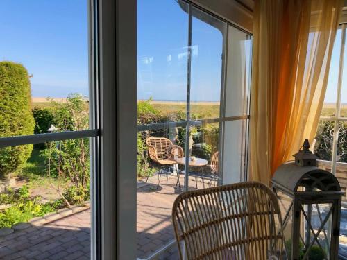 a room with a sliding glass door looking out onto a patio at Sonniges Strandhaus mit Wasserblick am Haff mit 2 Schlafzimmern für 4 Pers in Mönkebude
