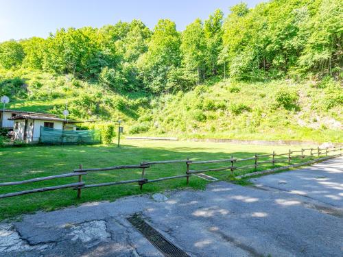 a wooden fence in front of a grass field at Campeggio Internazionale Madonna del Ghisallo in Magreglio