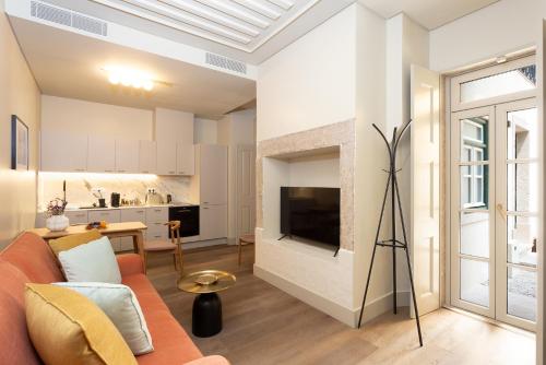 a living room with a couch and a tv at Hermitage Castelo - Casa Sé in Lisbon