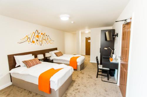 ein Hotelzimmer mit 2 Betten und einem Schreibtisch in der Unterkunft Whiteley Mill in Stapleford