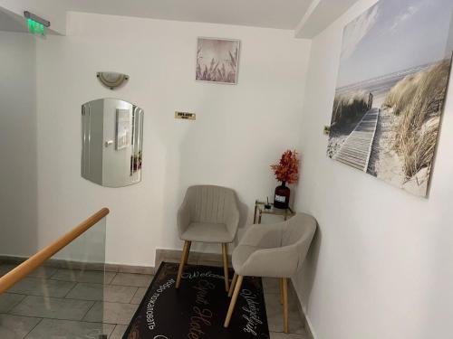 a dining room with two chairs and a refrigerator at Esprit Hotel in Budapest