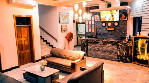 a living room with a couch and a fireplace at MK Hotel in Muisenge