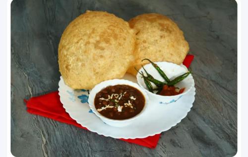a plate of food with bread and a bowl of dips at Hotel Airport Suites Suitable for Hourly Bookings in Lucknow