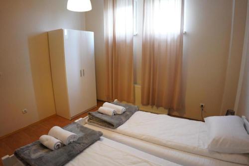 a bedroom with two beds and a dresser at Apartmani Kula - Apartman 2 in Novi Banovci
