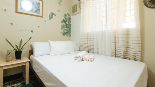 a bedroom with a bed with two towels on it at Jb's Transient House in General Trias