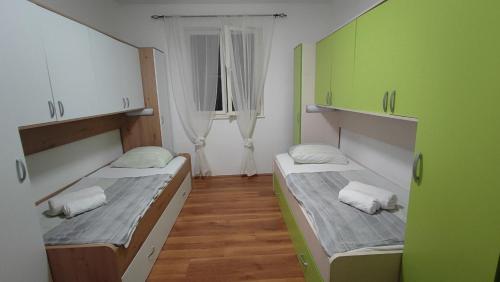two beds in a small room with a window at Laura in Koromačno