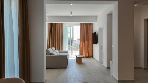 a living room with a couch and a large window at Alpesa Apartments in Budva