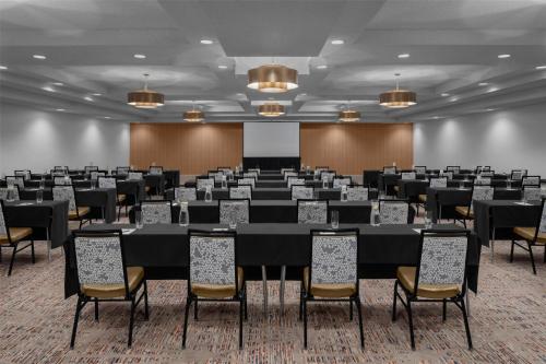 a conference room with tables and chairs and a screen at Embassy Suites by Hilton Phoenix Biltmore in Phoenix