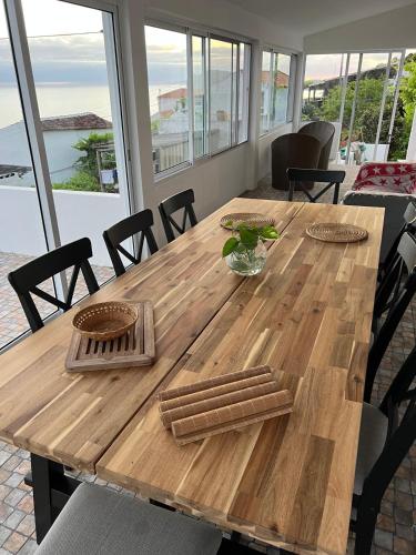 a wooden table in a room with a view of the ocean at Casa da Vinha in Feteira