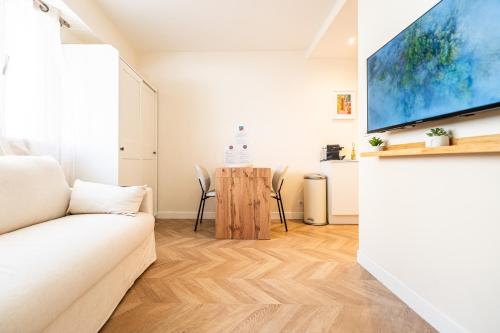 un salon avec un canapé blanc et une table dans l'établissement L'Escale Niçoise, à Nice