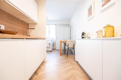 - une cuisine et une salle à manger avec des placards blancs et une table dans l'établissement L'Escale Niçoise, à Nice