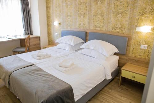 a bedroom with a large bed with white sheets and pillows at Hotel Olanesti & Spa Medical in Băile Olăneşti