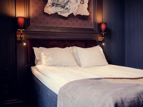 a bed with white sheets and pillows in a room at Stora Hotellet; BW Premier Collection in Umeå