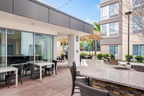a patio with chairs and tables and a building at Homewood Suites By Hilton San Jose Santa Clara in San Jose