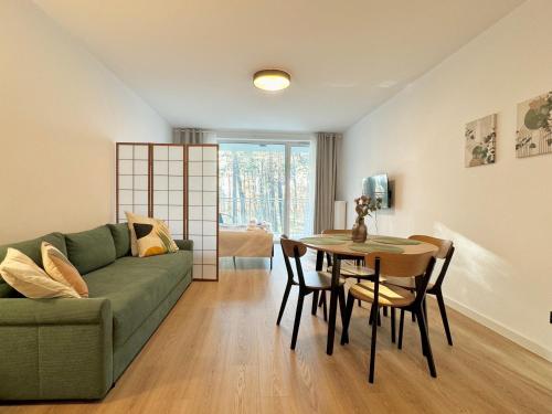 a living room with a green couch and a table at Apartamenty Florina Q4Apartments in Łeba