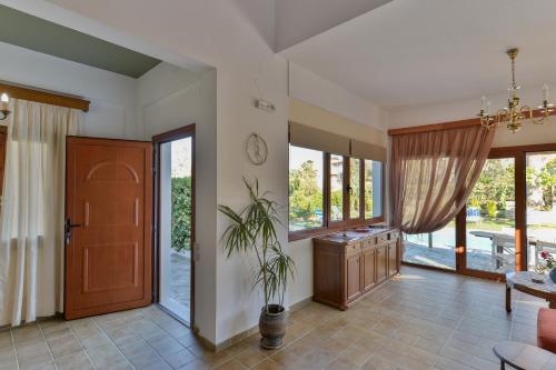 a living room with a door and a table with a plant at Villa Muse in Pitsidia