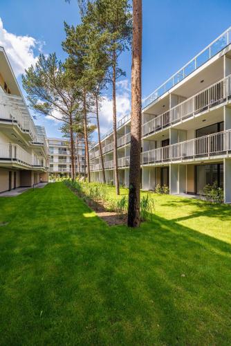 an empty lawn in front of an apartment building at Apartamenty Florina Q4Apartments in Łeba