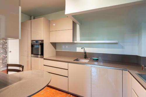 une cuisine avec des armoires blanches et une table dans l'établissement Cardinale 4 rooms, à Aix-en-Provence